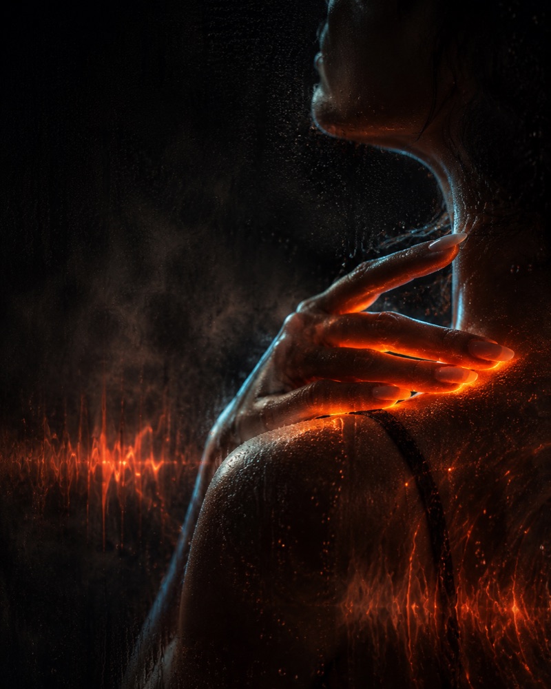 A hand pressed to a shoulder, glowing along the fingers
